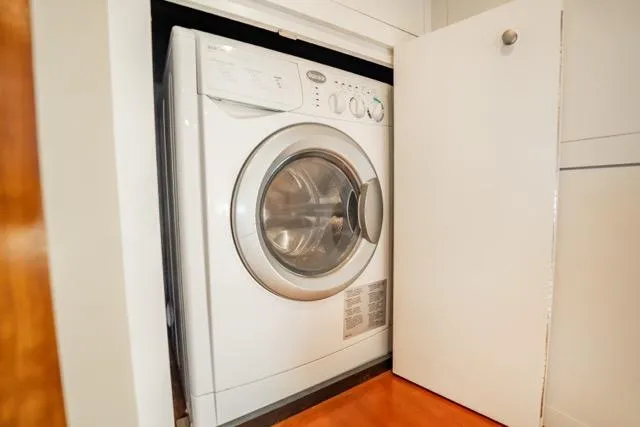 Slide: The Image of Washing machine in 2005 Cruiser Yachts 405 EXPRESS, partially enclosed by a cabinet door. - 71