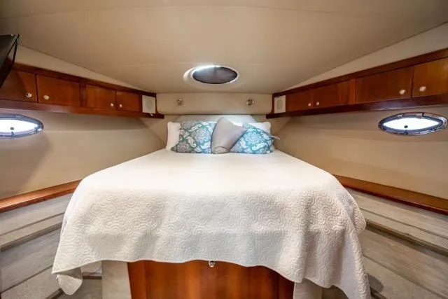 Slide: The Image of Luxurious cabin interior of 2005 Cruiser Yachts 405 EXPRESS with cozy bed and elegant wood finish. - 8