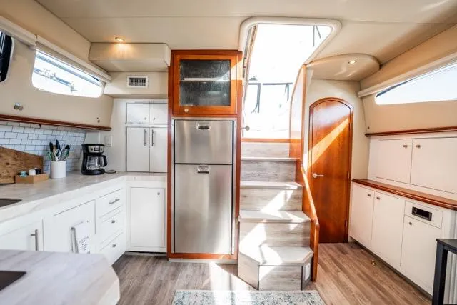 Slide: The Image of 2005 Cruiser Yachts 405 EXPRESS interior with modern kitchen and wooden accents. - 9