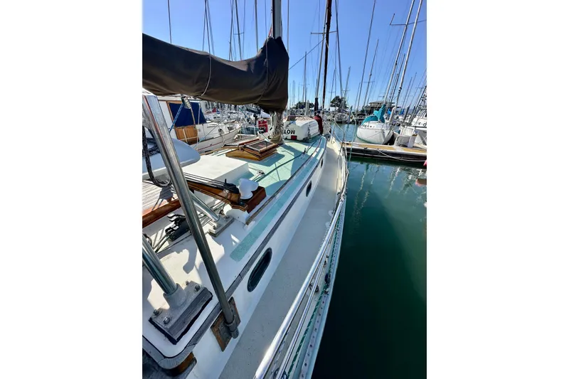Slide: The Image of 1978 Tayana 37 sailboat docked in a marina, surrounded by other boats. - 12