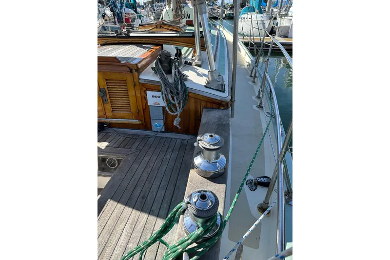 Slide: The Image of 1978 Tayana 37 sailboat deck with winches and ropes in a marina setting. - 14