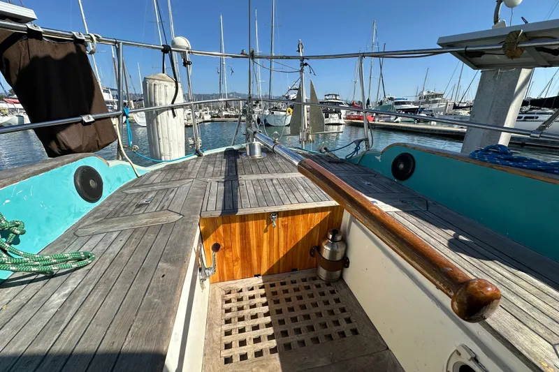 Slide: The Image of 1978 Tayana 37 sailboat cockpit with wooden deck, docked in a marina. - 15
