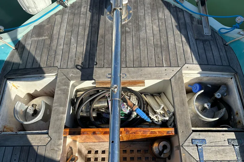 Slide: The Image of 1978 Tayana 37 sailboat deck with storage compartments and nautical equipment. - 16