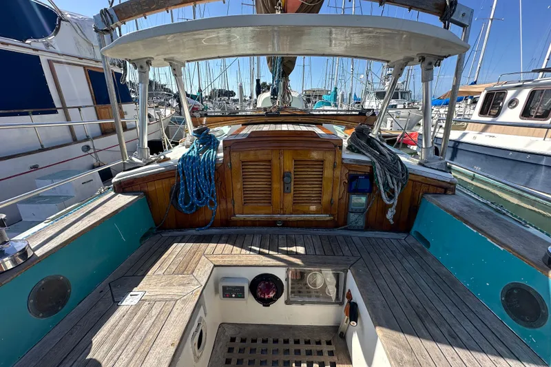 Slide: The Image of Cockpit of a 1978 Tayana 37 sailboat with wooden accents and nautical ropes. - 17