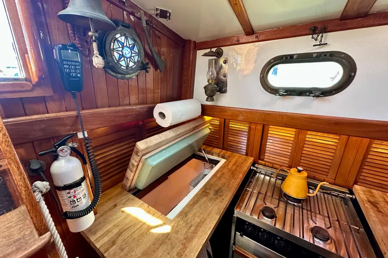 Slide: The Image of Interior of 1978 Tayana 37 sailboat galley with wooden finish and vintage decor. - 22