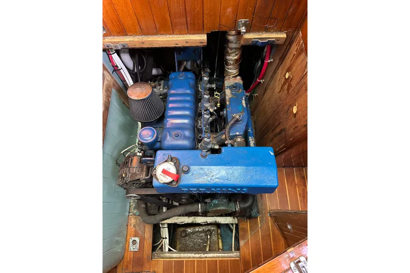 Slide: The Image of Engine compartment of a 1978 Tayana 37 sailboat, featuring a blue marine engine. - 28