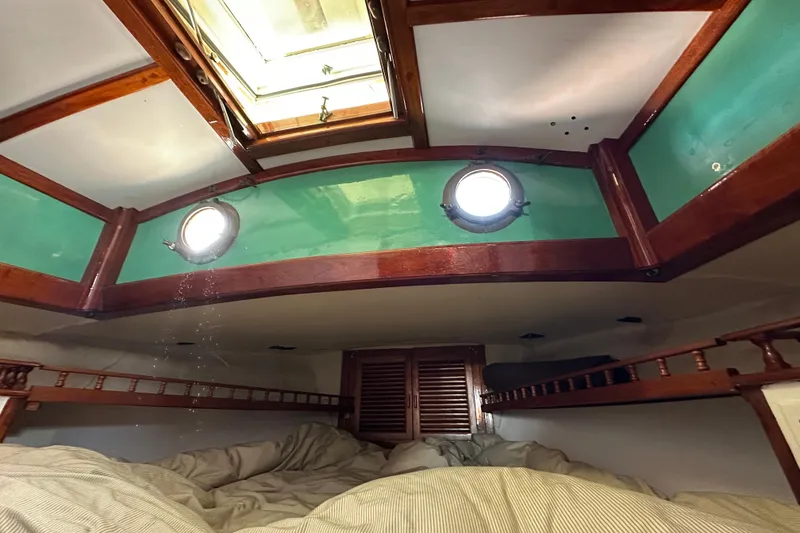 Slide: The Image of Cozy cabin interior of 1978 Tayana 37 sailboat with wooden accents and portholes. - 36