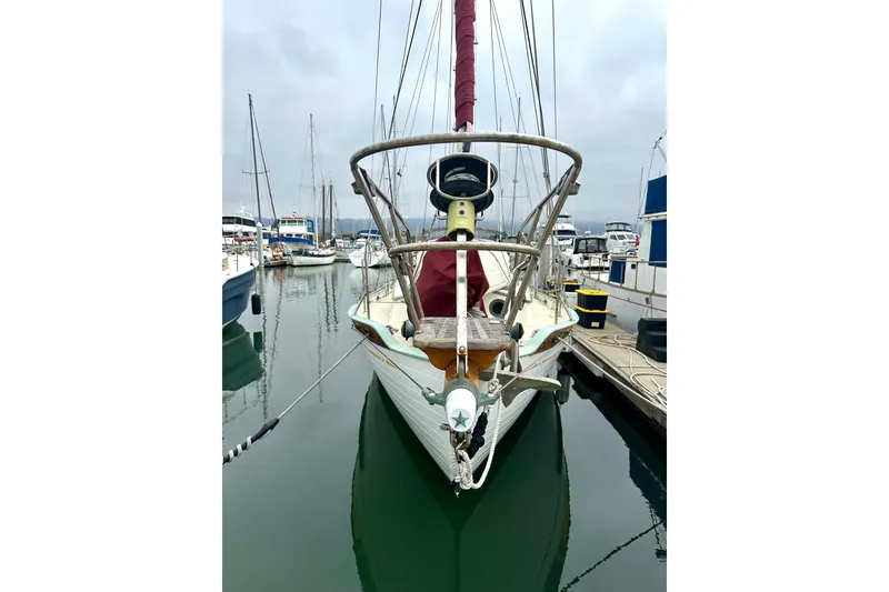 Slide: The Image of 1978 Tayana 37 sailboat docked in a marina, front view with masts and rigging. - 6