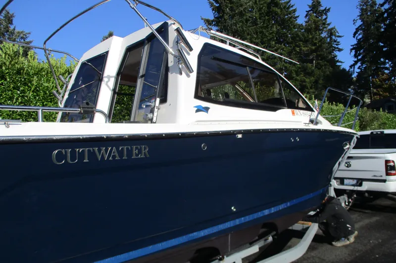 Slide: The Image of 2018 Cutwater C-24 boat on trailer, blue hull, parked outdoors. - 18