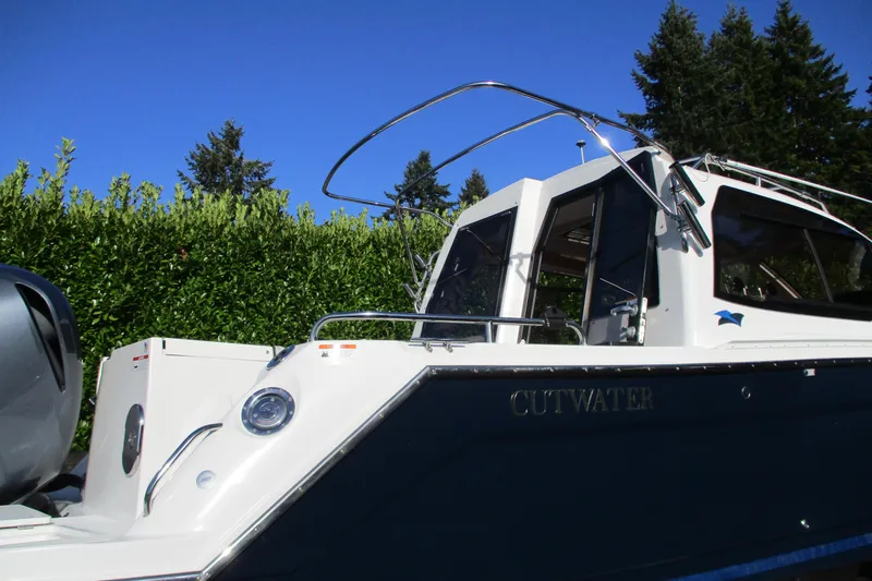 Slide: The Image of 2018 Cutwater C-24 boat with sleek design, set against a clear blue sky and lush greenery. - 19