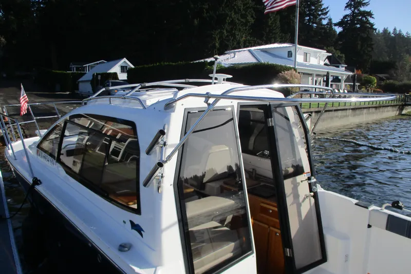 Slide: The Image of 2018 Cutwater C-24 boat docked by waterfront home, American flag visible. - 20