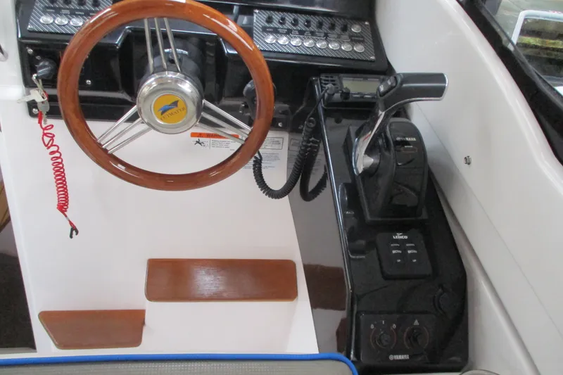 Slide: The Image of 2018 Cutwater C-24 helm with wooden steering wheel and control panel. - 24