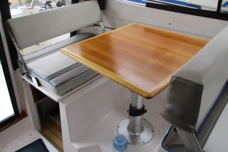 Slide: The Image of Interior of 2018 Cutwater C-24 boat with wooden table and cushioned seating. - 26