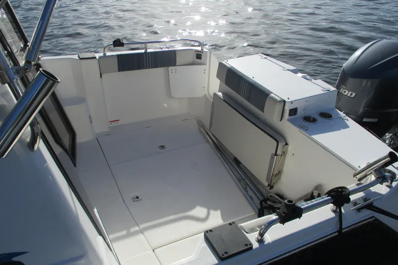 Slide: The Image of 2018 Cutwater C-24 boat interior with seating and storage, docked on calm water. - 3