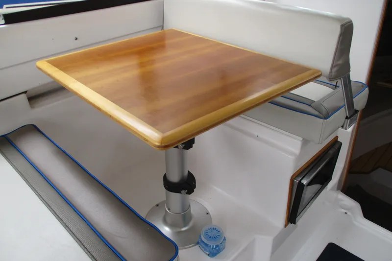 Slide: The Image of Interior of 2018 Cutwater C-24 boat with wooden table and cushioned seating. - 30