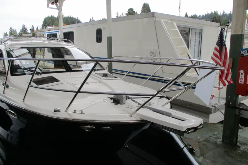 Slide: The Image of 2018 Cutwater C-24 boat docked near a houseboat with American flag. - 4