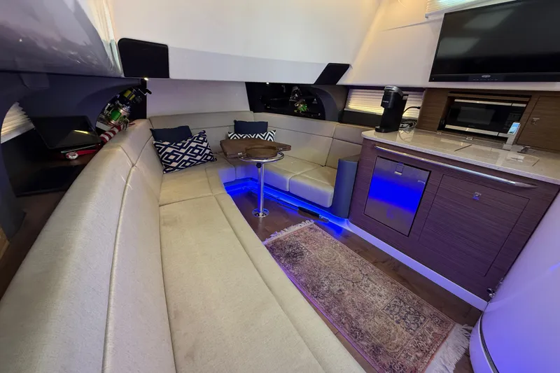Slide: The Image of Luxurious interior of 2020 Boston Whaler 420 Outrage with seating, kitchenette, and ambient lighting. - 13
