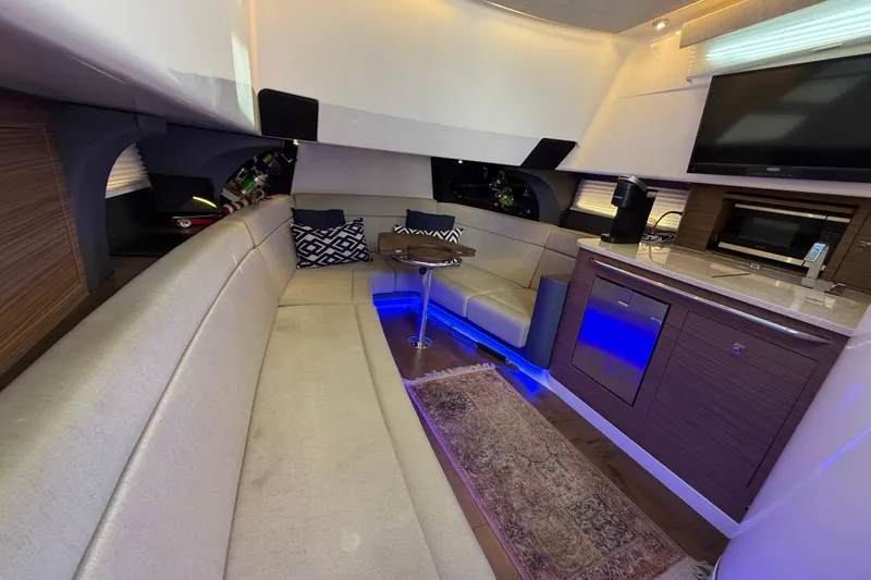 Slide: The Image of Luxurious interior of 2020 Boston Whaler 420 Outrage with seating, kitchenette, and ambient lighting. - 15