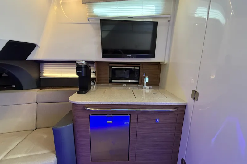 Slide: The Image of Interior of 2020 Boston Whaler 420 Outrage with kitchenette, TV, and seating area. - 16