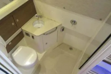 Slide: The Image of 2020 Boston Whaler 420 Outrage bathroom with sink, toilet, and shower area. - 17