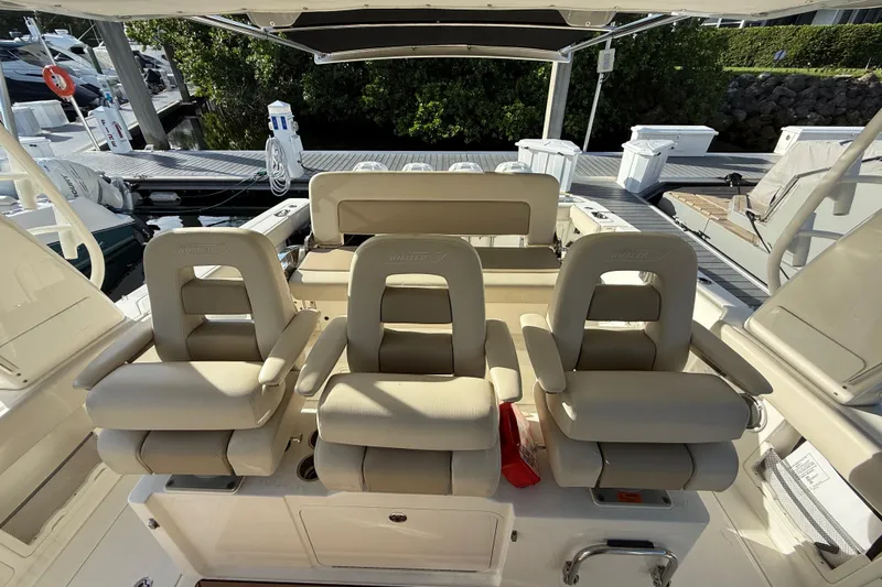 Slide: The Image of 2020 Boston Whaler 420 Outrage boat interior with three beige captain's chairs. - 7