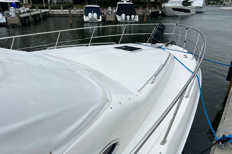 Slide: The Image of 2000 Sea Ray 400 Sedan Bridge yacht docked at marina, featuring sleek white design. - 10