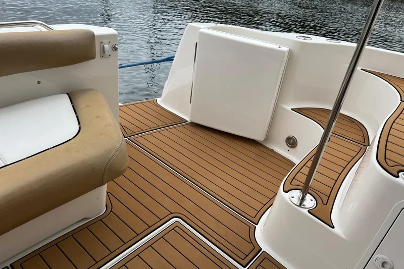 Slide: The Image of Deck of 2000 Sea Ray 400 Sedan Bridge with cushioned seating and wood-style flooring. - 17