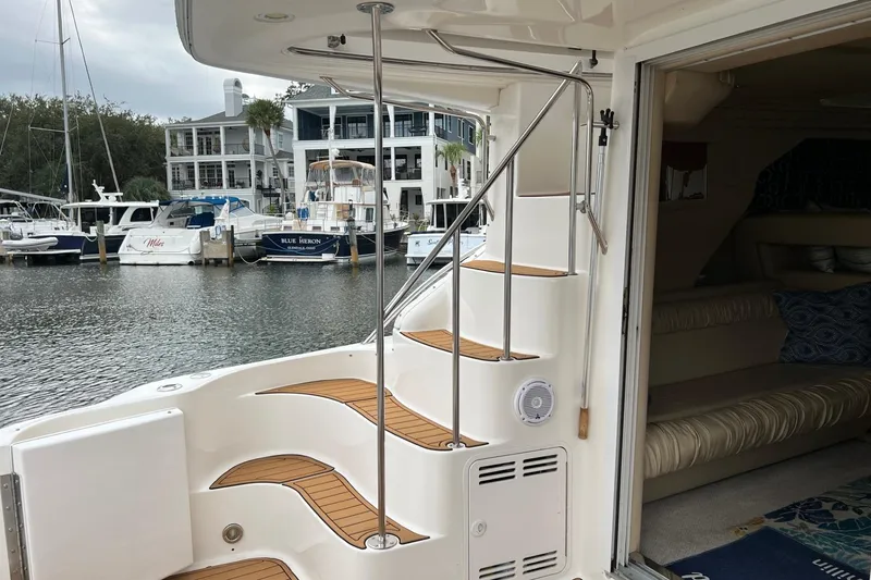Slide: The Image of 2000 Sea Ray 400 Sedan Bridge yacht interior with staircase and marina view. - 18