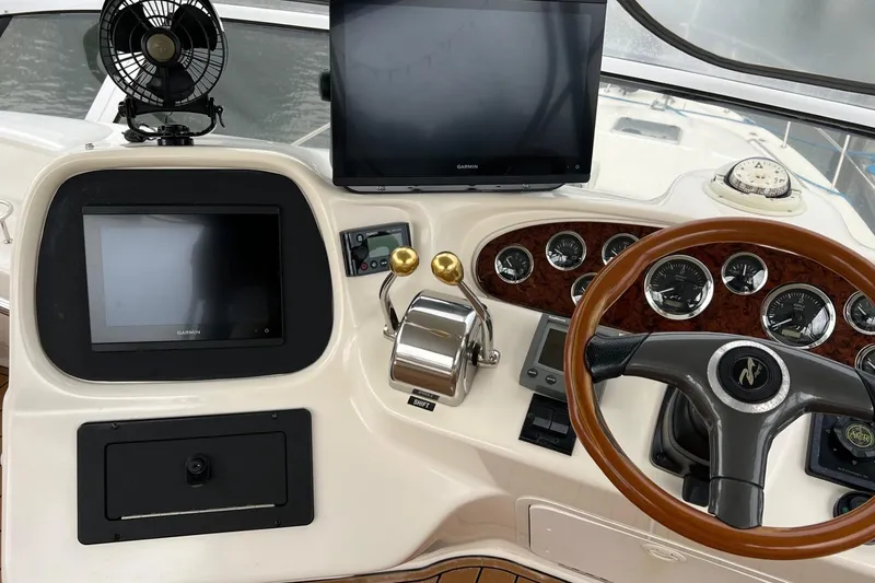 Slide: The Image of Control panel of a 2000 Sea Ray 400 Sedan Bridge with steering wheel and navigation screens. - 24