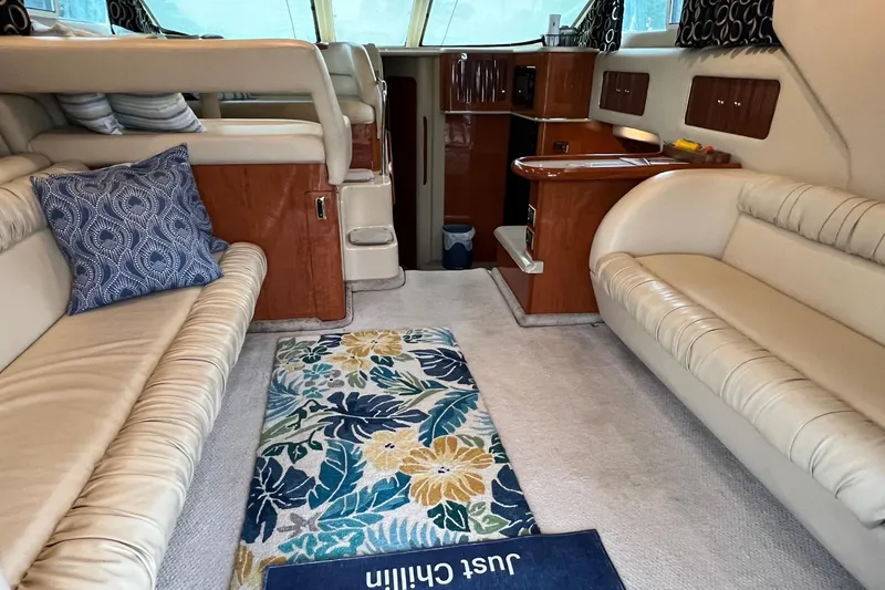 Slide: The Image of Interior of 2000 Sea Ray 400 Sedan Bridge with beige seating and floral rug. - 37