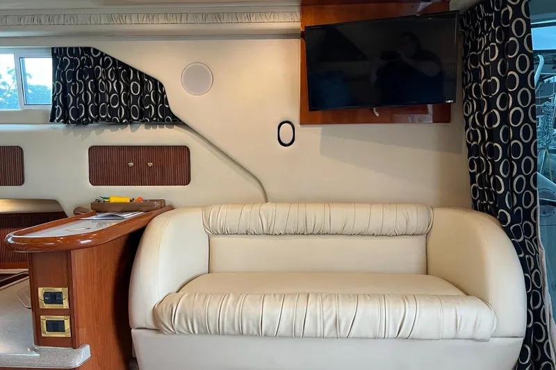 Slide: The Image of Interior of 2000 Sea Ray 400 Sedan Bridge with sofa, TV, and patterned curtains. - 40