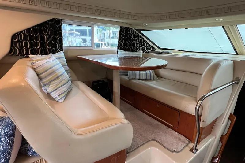 Slide: The Image of Interior of 2000 Sea Ray 400 Sedan Bridge with plush seating and dining table. - 42