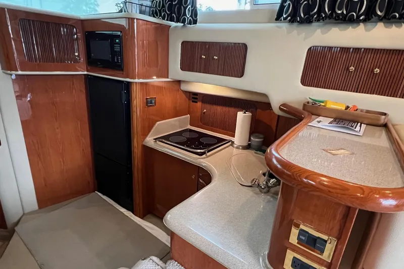 Slide: The Image of 2000 Sea Ray 400 Sedan Bridge yacht kitchen with wood cabinetry and modern appliances. - 45