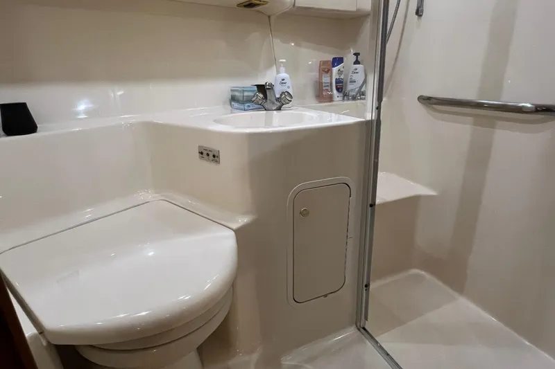 Slide: The Image of Bathroom interior of 2000 Sea Ray 400 Sedan Bridge yacht, featuring toilet and shower. - 58