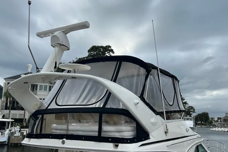 Slide: The Image of 2000 Sea Ray 400 Sedan Bridge yacht with enclosed flybridge, docked under cloudy skies. - 6