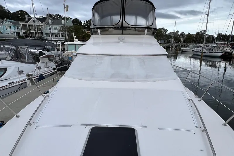 Slide: The Image of 2000 Sea Ray 400 Sedan Bridge yacht docked at marina, showcasing sleek design and spacious deck. - 9