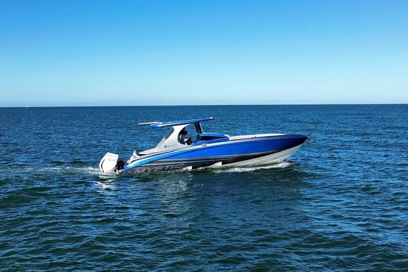 Slide: The Image of 2023 Mystic Powerboats M3800 cruising on open water under clear blue skies. - 0