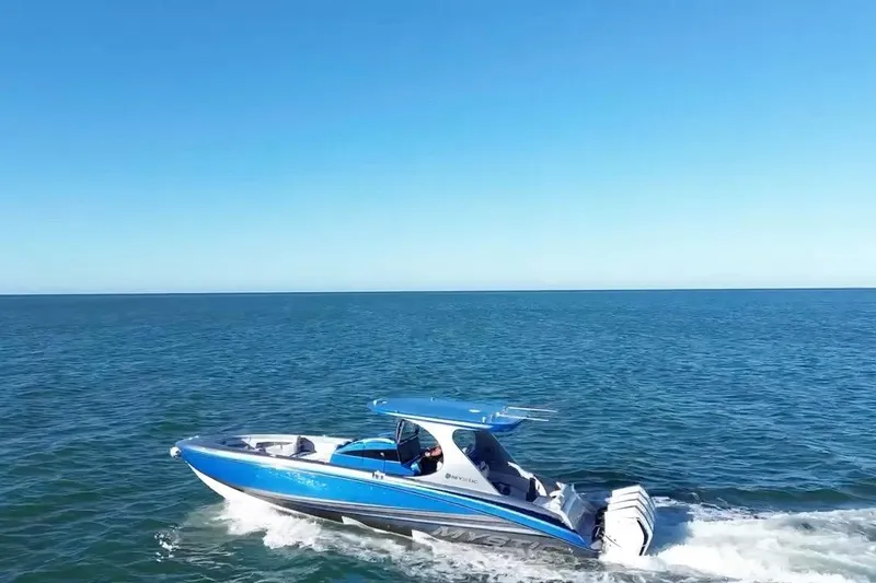 Slide: The Image of 2023 Mystic Powerboats M3800 cruising on open blue ocean under clear sky. - 11