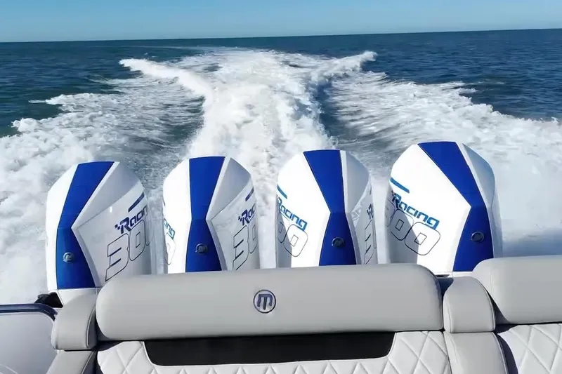 Slide: The Image of 2023 Mystic Powerboats M3800 with four powerful outboard engines on open water. - 13