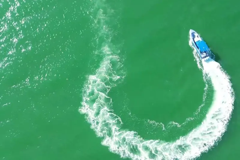 Slide: The Image of Aerial view of 2023 Mystic Powerboats M3800 making a sharp turn on green water. - 14