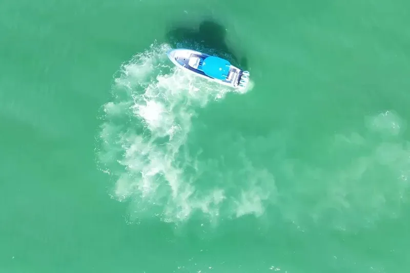 Slide: The Image of Aerial view of 2023 Mystic Powerboats M3800 cruising in turquoise waters. - 16
