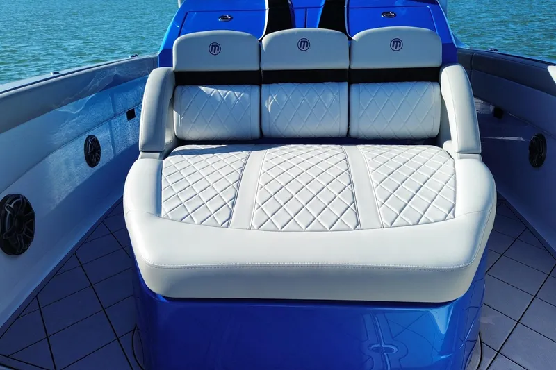 Slide: The Image of 2023 Mystic Powerboats M3800 interior with luxurious quilted seating on a sunny day. - 18