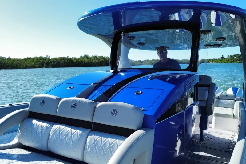 Slide: The Image of 2023 Mystic Powerboats M3800 on water, featuring sleek blue design and luxurious seating. - 19