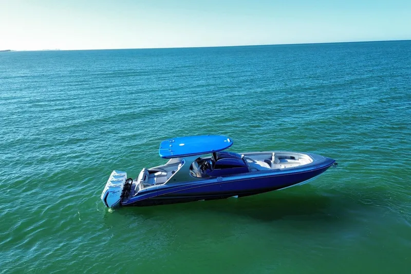 Slide: The Image of 2023 Mystic Powerboats M3800 cruising on calm blue waters. - 2