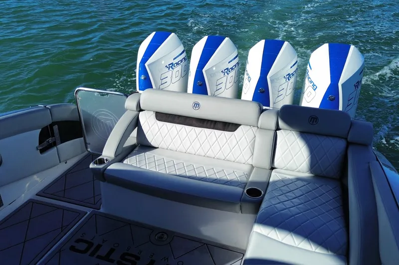 Slide: The Image of 2023 Mystic Powerboats M3800 with quad engines, luxurious seating, and sleek design on water. - 22