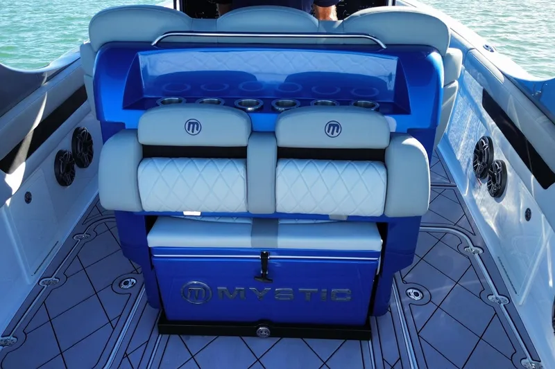 Slide: The Image of 2023 Mystic Powerboats M3800 interior with blue and white seating and cup holders. - 23