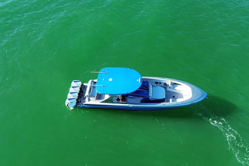 Slide: The Image of 2023 Mystic Powerboats M3800 cruising on vibrant green water. - 3