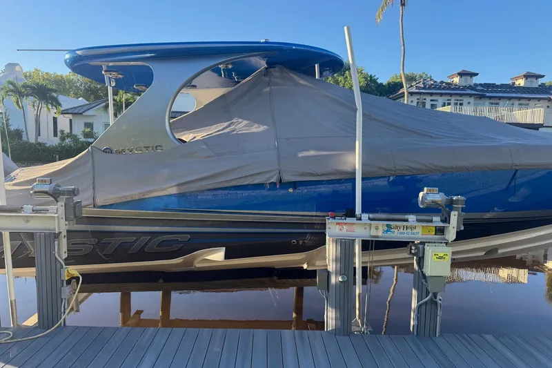 Slide: The Image of 2023 Mystic Powerboats M3800 covered on a dock with hoist system. - 32