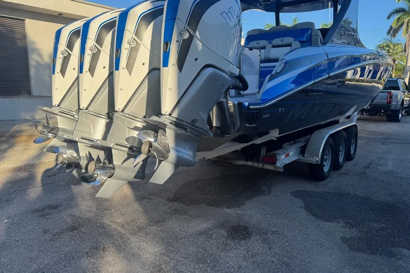 Slide: The Image of 2023 Mystic Powerboats M3800 with quad engines on a trailer, showcasing sleek design. - 34