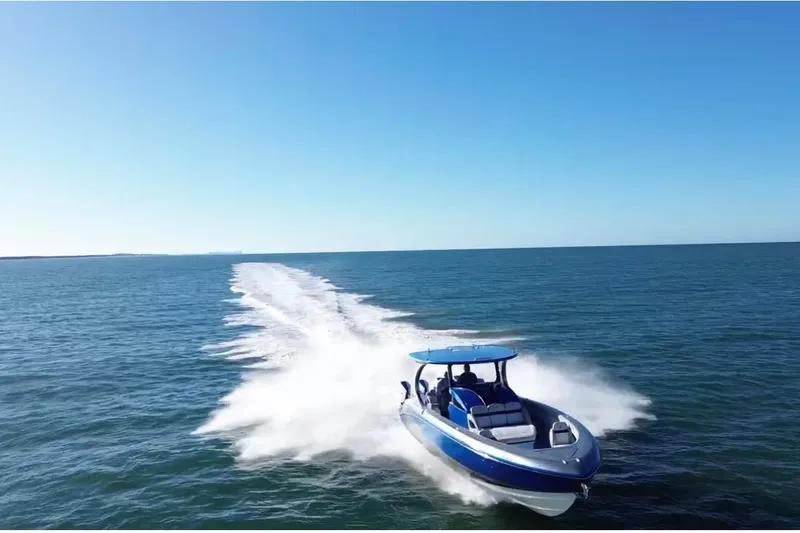Slide: The Image of 2023 Mystic Powerboats M3800 speeding on open water under clear blue skies. - 4